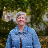 A woman with short hair in a blue jacket.