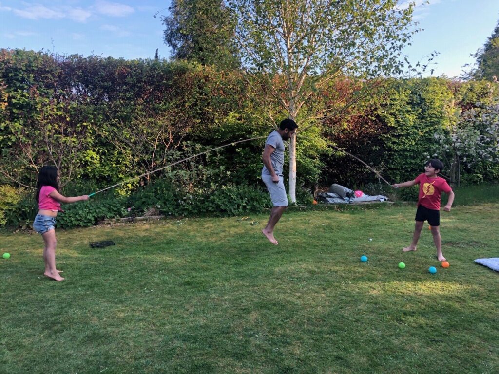 Dad and children skipping with rope