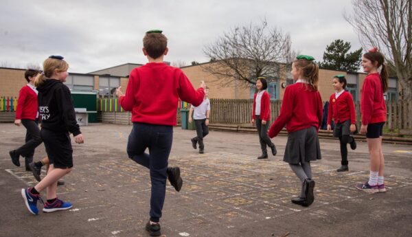 school activity break with pupils balancing in the playground