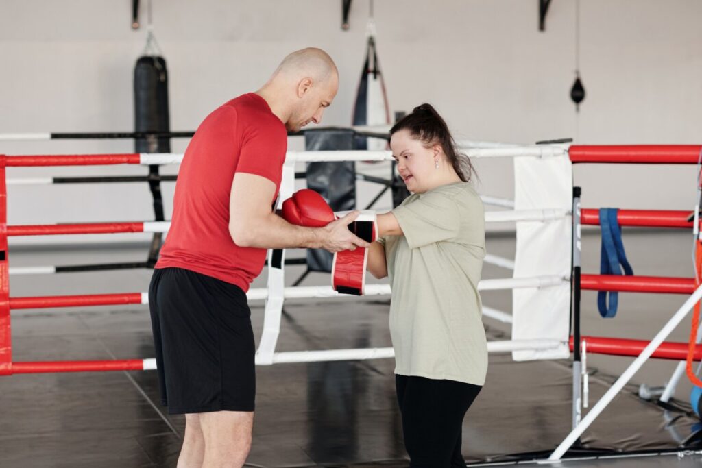 Women being assisted doing boxing (returning to physical activity)