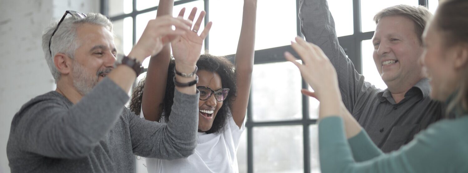 People standing with their arms in the air at work