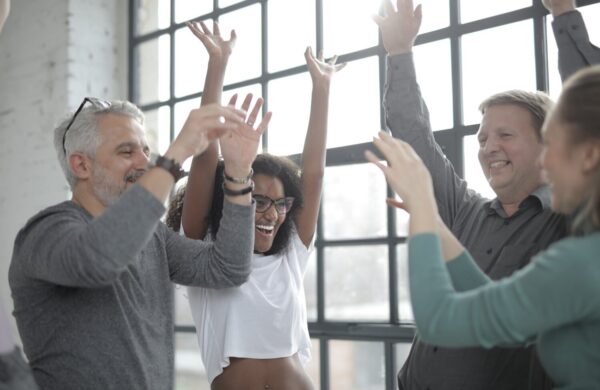 People standing with their arms in the air at work