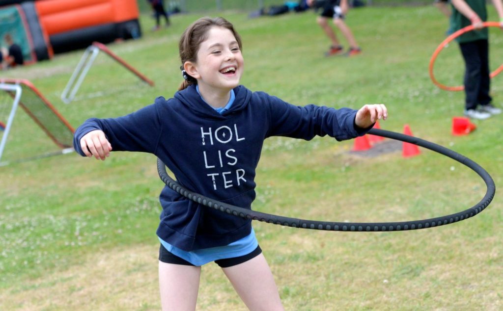 Girl hula hooping thanks to opening school facilities