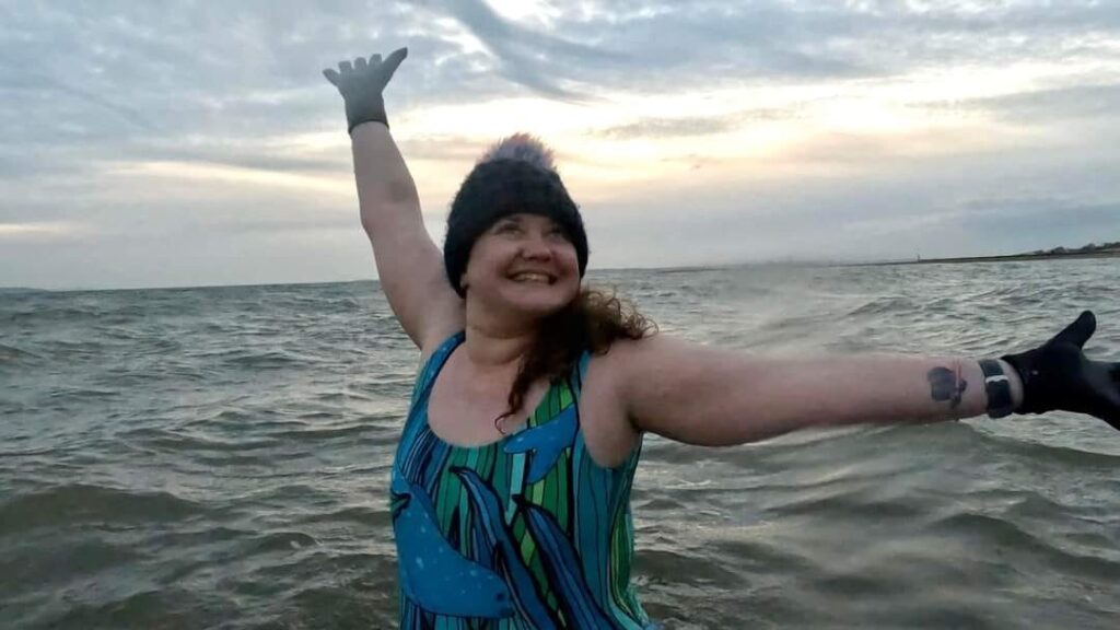 A woman smiling in the sea.