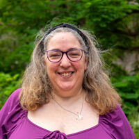 A woman smiling wearing glasses.