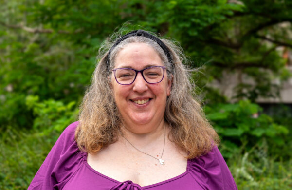 A woman smiling wearing glasses.