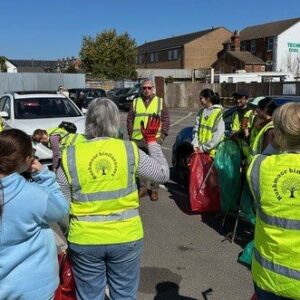A group of people, some in high-vis jackets, listening to an introductory speech.