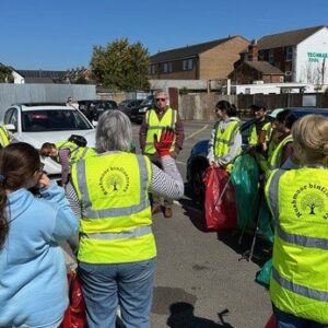 A group of people in high-vis jackets listening to the safety talk.