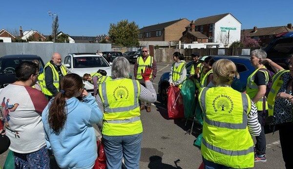 A group of people in high-vis jackets listening to the safety talk.