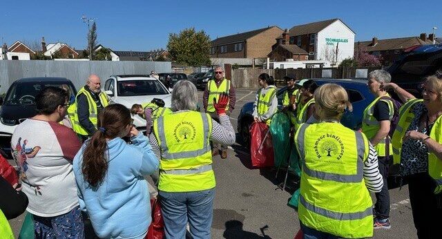 A group of people in high-vis jackets listening to the safety talk.