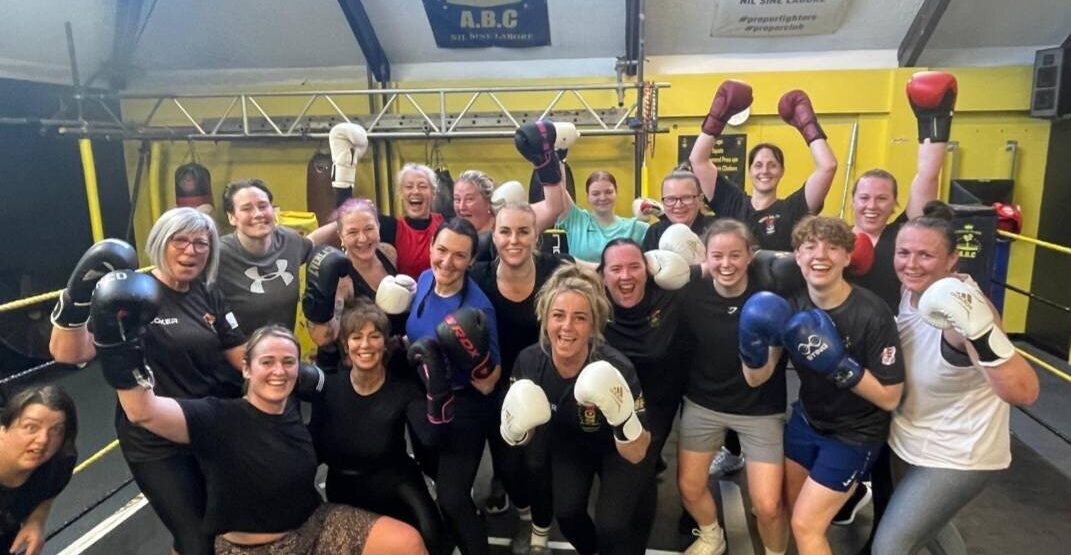 A group of women wearing their boxing gloves.