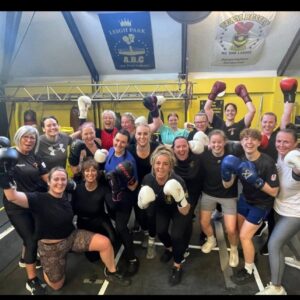 A group of women wearing their boxing gloves.