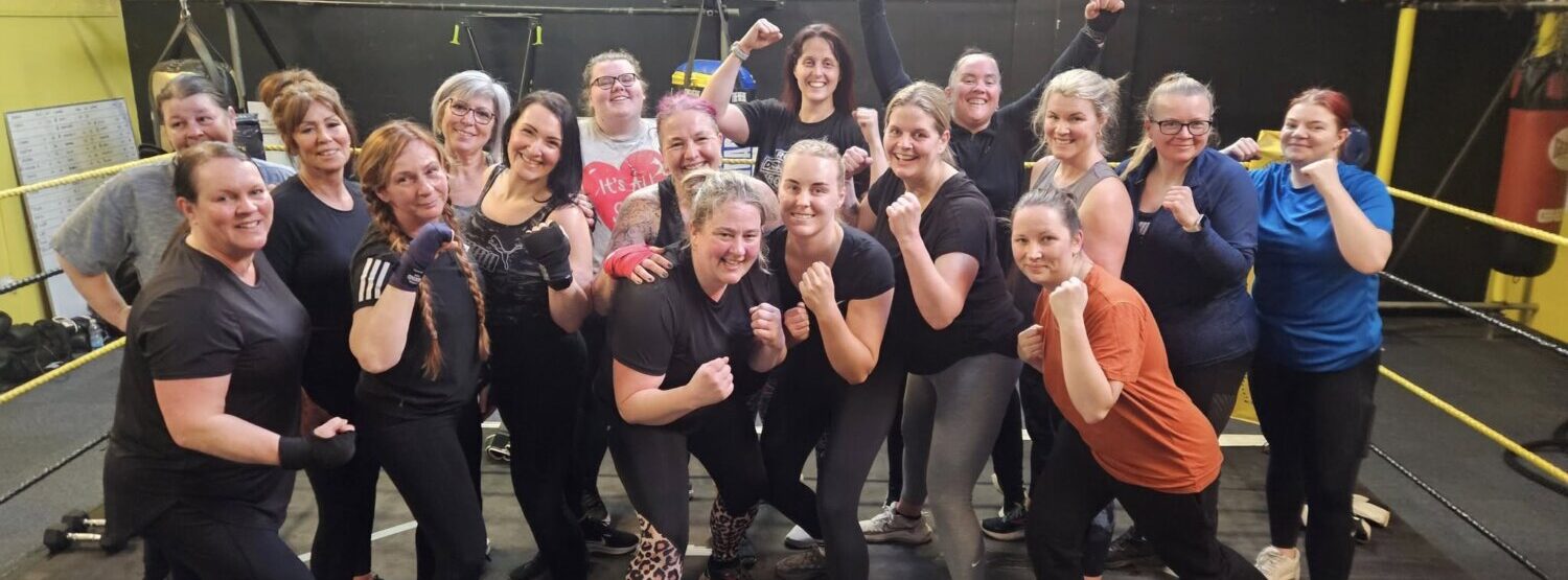 A group of women holding their hands in an uppercut position.