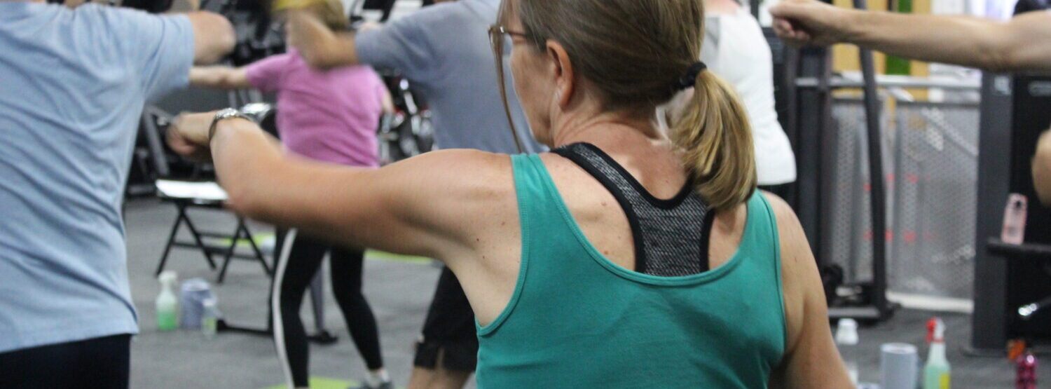 A woman punching forwards as part of her exercise class.