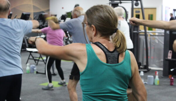 A woman punching forwards as part of her exercise class.