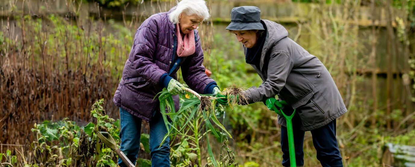 Two women in coats gardening.