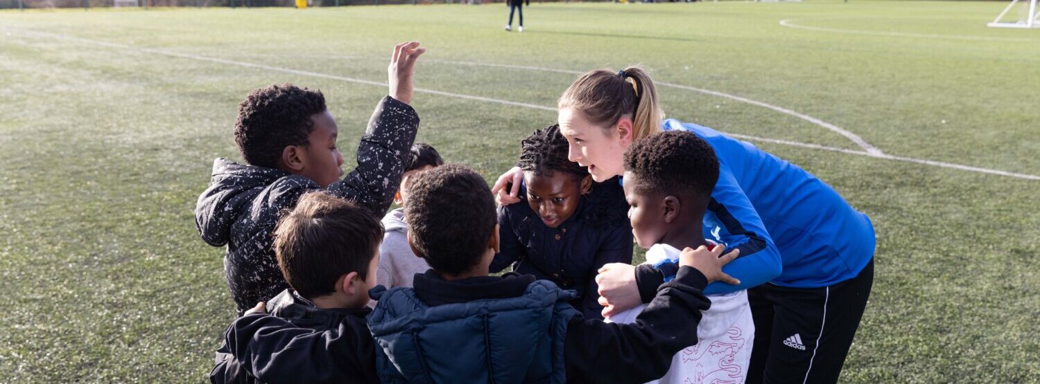 A coach huddling with her young players.