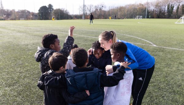 A coach huddling with her young players.