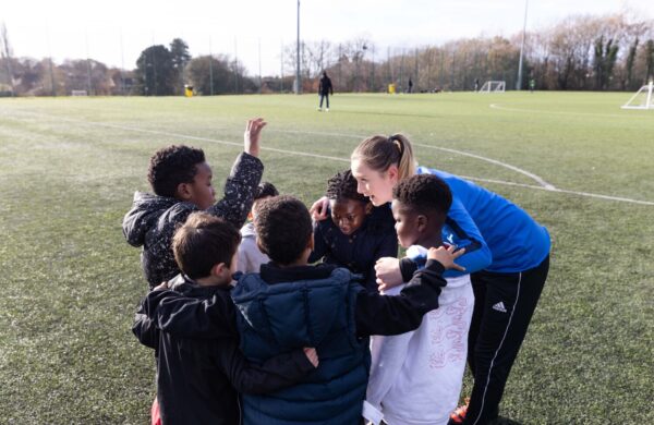 A coach huddling with her young players.