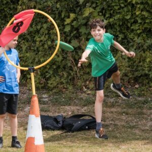 a young person throwing a frisbee through a hoop
