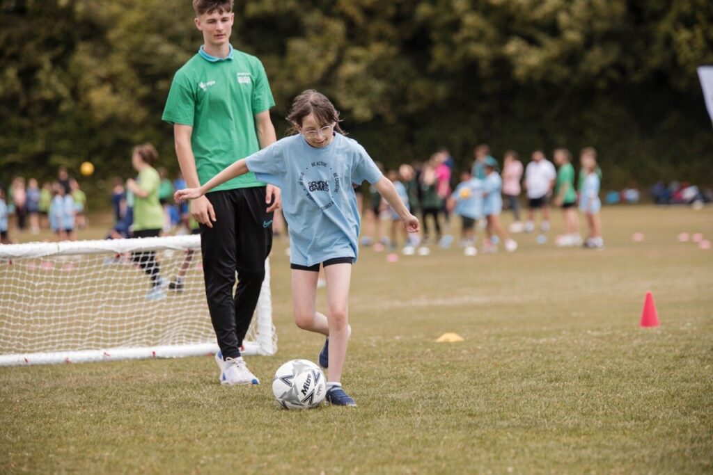 A young girl dribbling a football