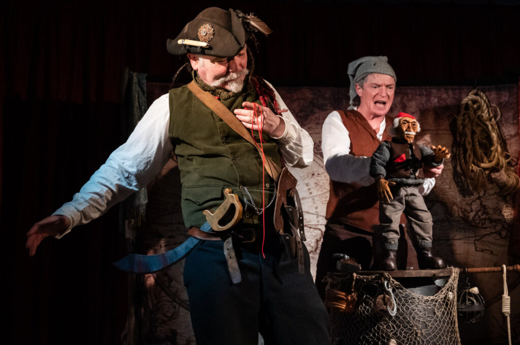 Two men dressed in pirate costumes performing on stage.