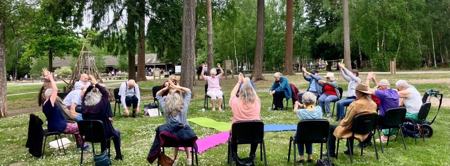An outdoor chair-based yoga class.