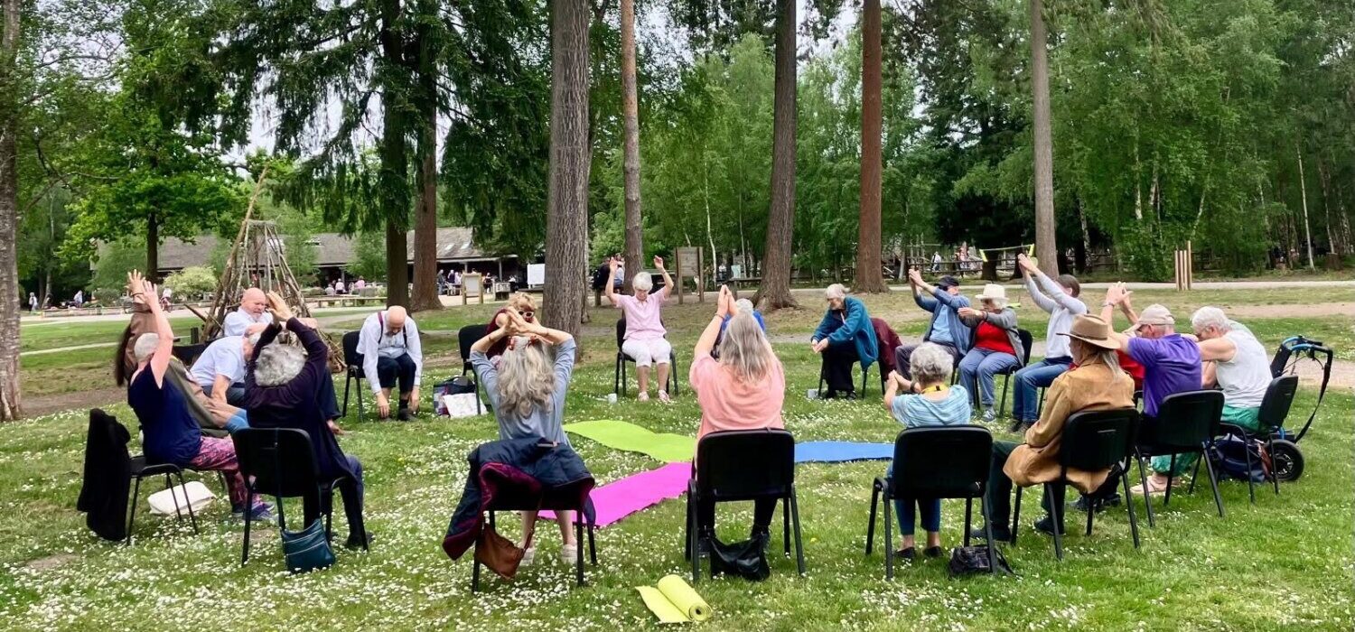 An outdoor chair-based yoga class.