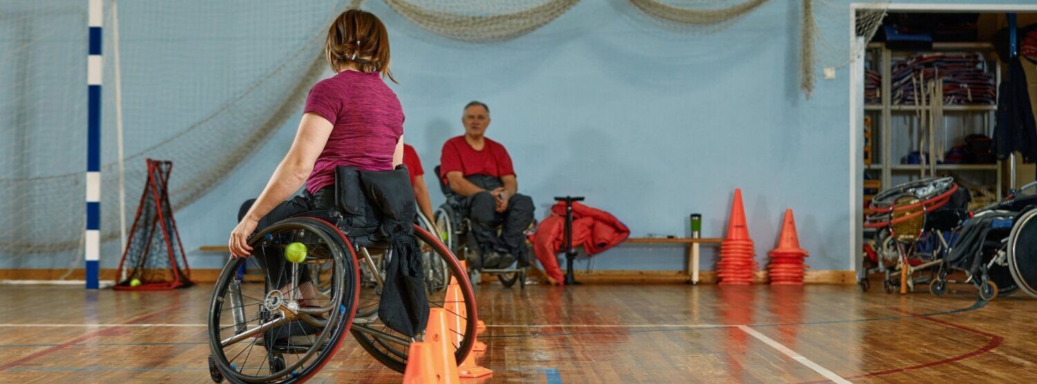 A person on a wheelchair weaving through cones.
