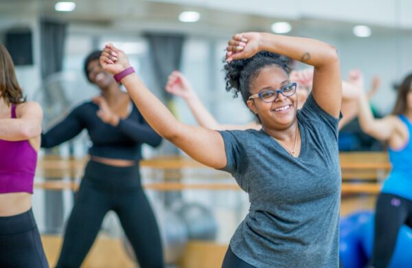 A woman dancing in a class with others.