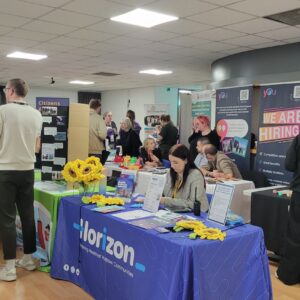 A room of stalls and people mingling.