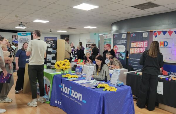 A room of stalls and people mingling.