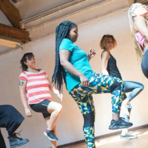 5 women of different ethnicities and sizes dancing.