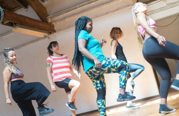 5 women of different ethnicities and sizes dancing.