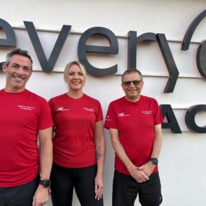 Left to Right: Chris Holliday - Mental Health Champion, Vicky Thorn - Mental Health Champion, Trevor Kettle - Mental Health Ambassador stood outside the Fareham Lesiure Centre. They are all wearing red tshirts and black bottoms